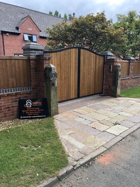 Bespoke hardwood double swing gate with curved top rail and intercom entry — automated timber gates North West