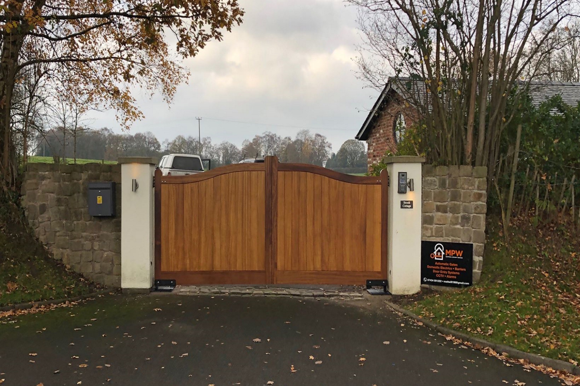Arched timber double swing gate with stone gateposts