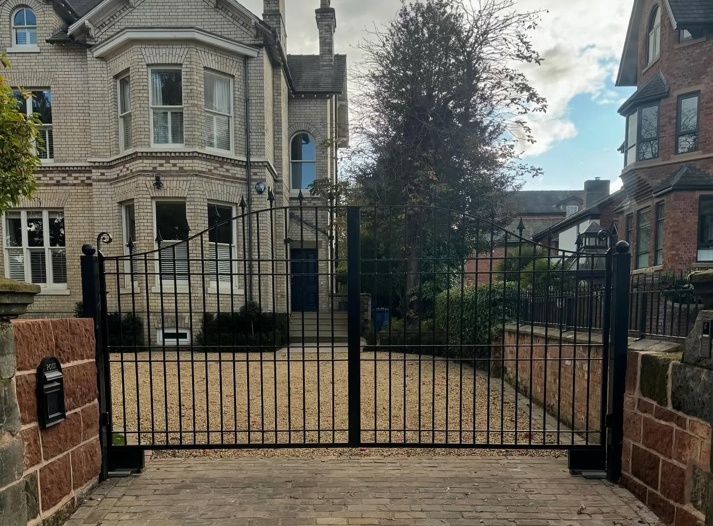 Traditional black wrought iron double swing gates with railings